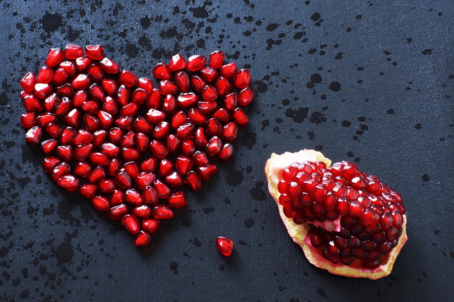 Pomegranate Seeds Are Stacked In The Form Of A Heart On A Black Background, Sprinkled With Water, Ne
